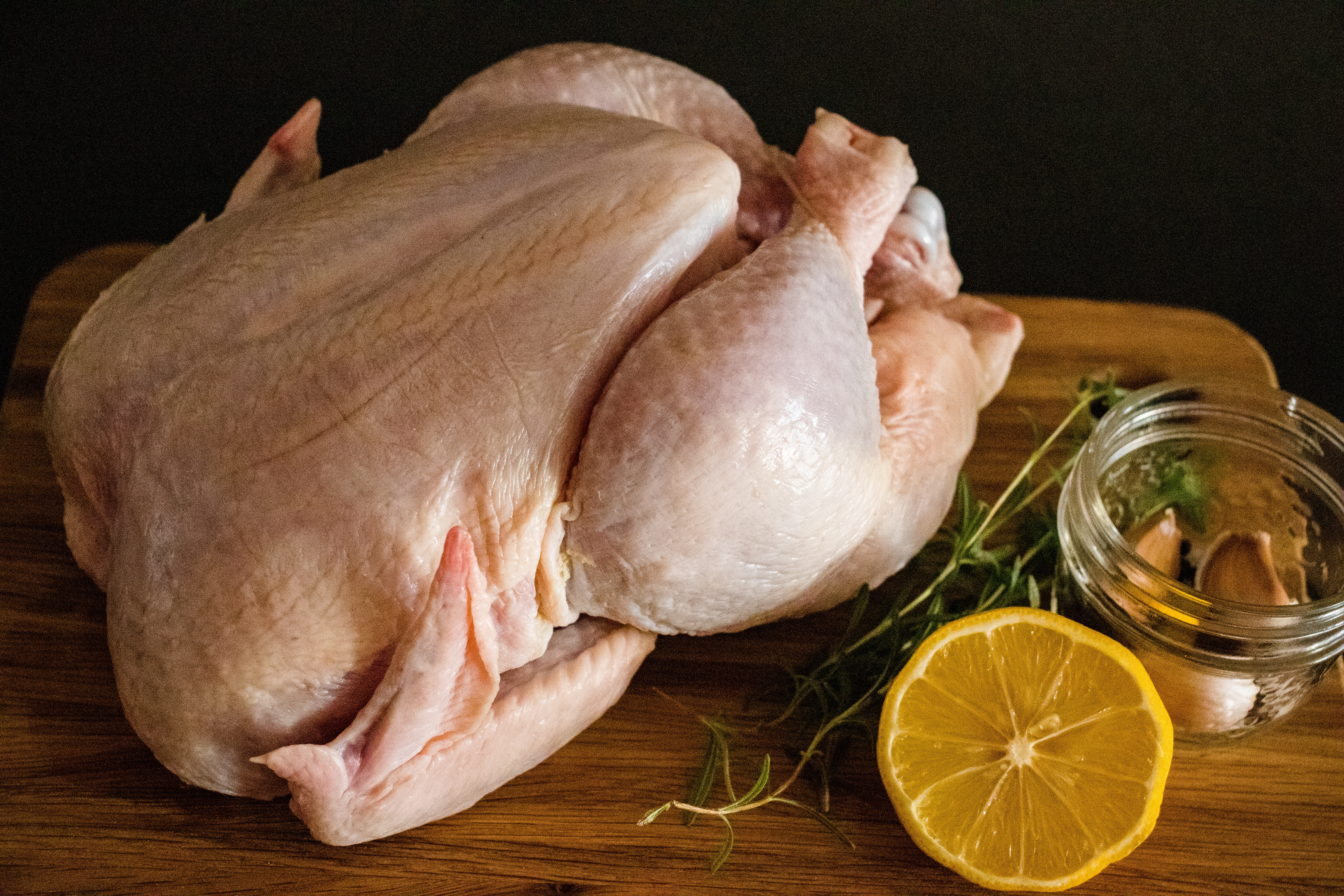 Ganzes Huhn auf dem Tisch mit GEwürzen